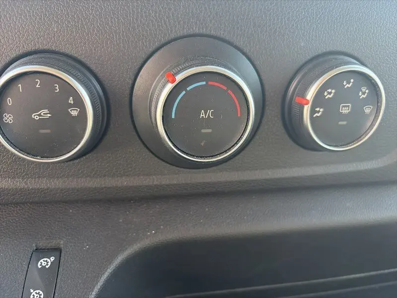 Gros plan sur les commandes de climatisation et ventilation du tableau de bord du Renault Master blanc de 2021.