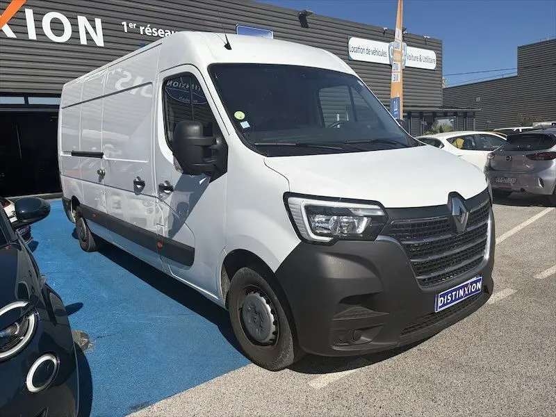 Renault Master blanc en 3/4 avant droit, grand utilitaire avec calandre noire et plaque Distinxion visible.