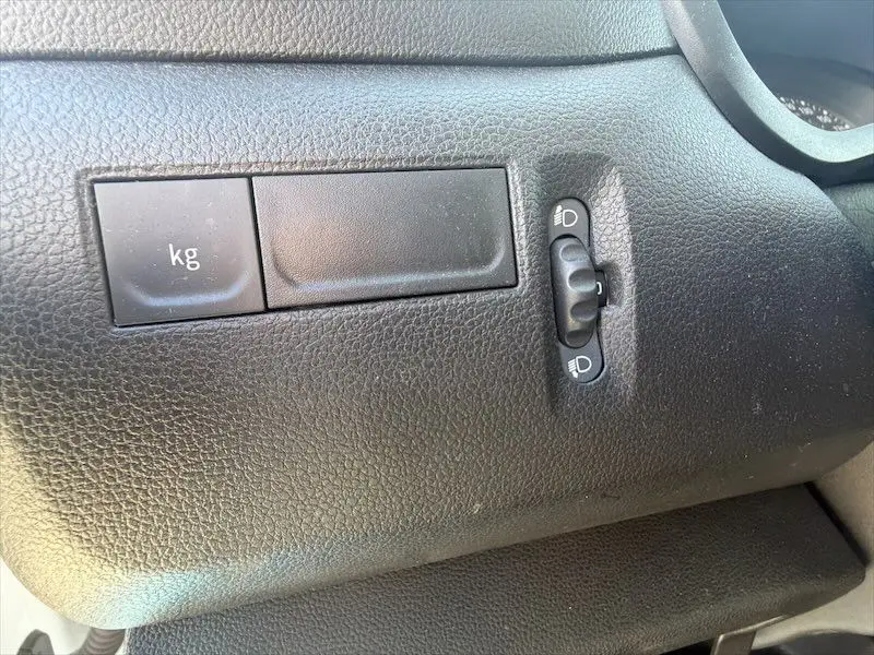 Détail intérieur du tableau de bord noir du Renault Master 2021 montrant un réglage de hauteur des phares et un cache marqué "kg".