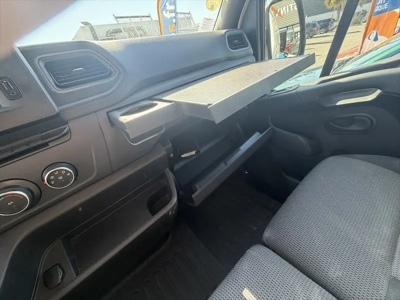Intérieur côté passager du Renault Master blanc 2021, montrant la planche à dessin déployée et la boîte à gants ouverte.