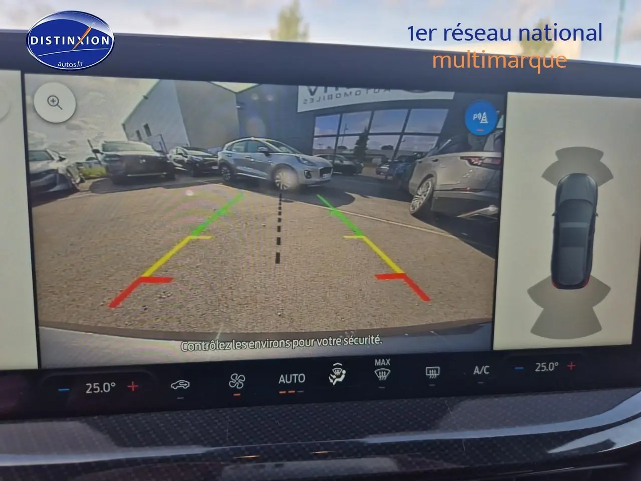 Écran de caméra de recul d'une Ford Focus gris magnétique, vue arrière avec lignes de guidage colorées.