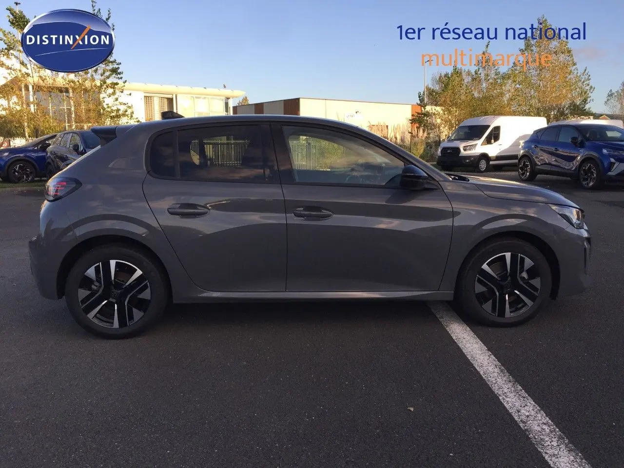 Profil côté gauche d'une Peugeot 208 gris selenium métal 2025, hybride essence, avec jantes noires et argentées.