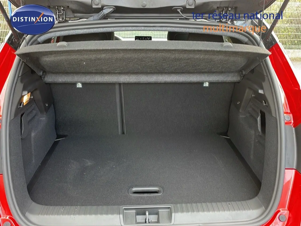 Coffre ouvert d'un Renault Captur rouge passion métal avec toit noir, vue arrière montrant l'espace de chargement vide.