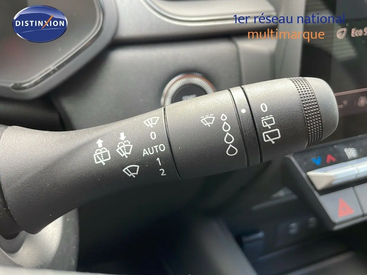 Gros plan sur la commande des essuie-glaces dans l'habitacle du Renault Captur rouge passion 2025 avec toit noir.