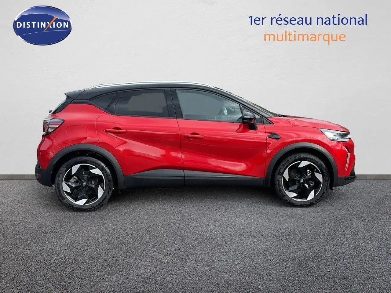 Profil côté gauche d'un Renault Captur E-Tech hybride rouge passion avec toit noir et jantes 18 pouces bicolores.