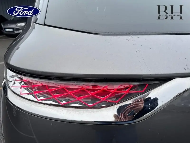 Gros plan sur le feu arrière droit du DS7 Crossback gris Platinium avec motif géométrique rouge et contour chromé.