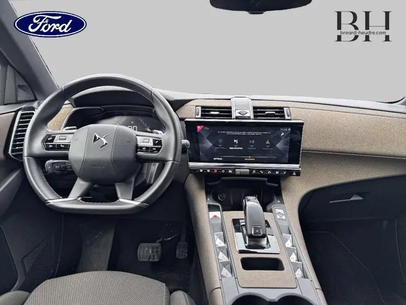 Vue intérieure du tableau de bord et volant cuir noir du DS7 Crossback 2020 avec écran tactile central et sellerie tissu bronze.