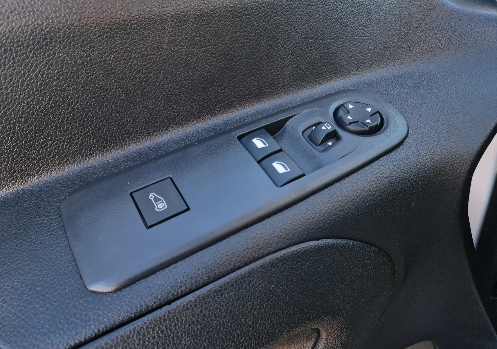 Gros plan sur les commandes de réglage des rétroviseurs et vitres côté conducteur du Peugeot Partner blanc 2021.