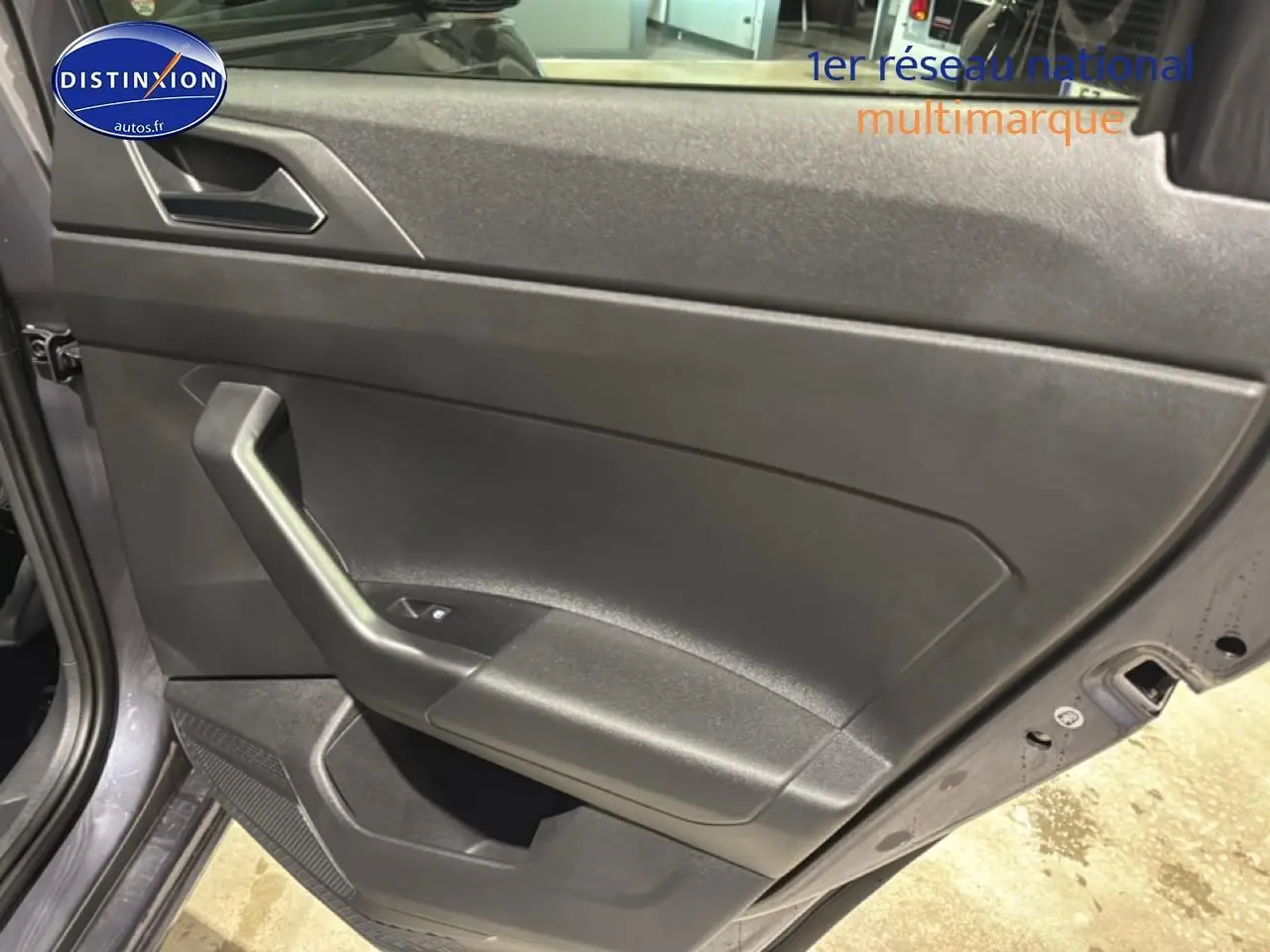 Vue rapprochée de la porte avant gauche gris cendre d'une Volkswagen Polo 2025 avec poignée intégrée et commande de vitre.