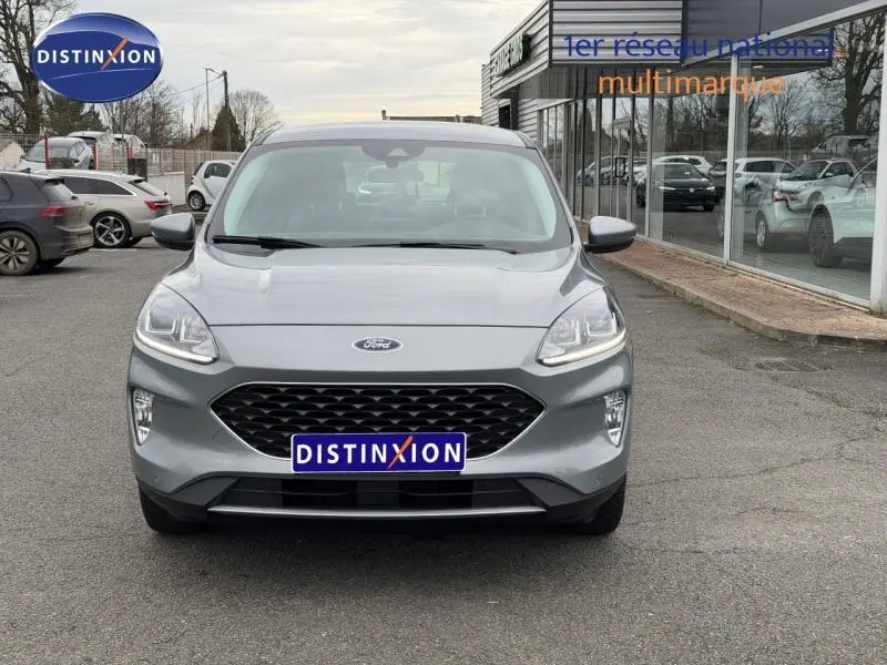 Vue de face du Ford Kuga 1.5 EcoBoost 150ch Titanium gris 2024, avec calandre hexagonale et phares LED allumés.