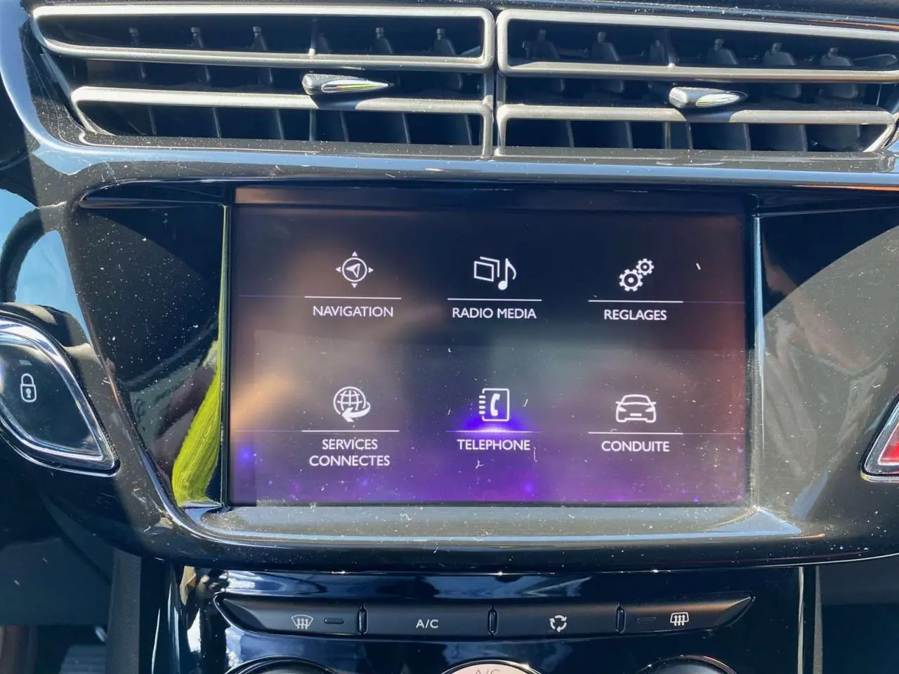 Écran tactile central du DS3 2018 affichant les options navigation, radio, téléphone et réglages, avec tableau de bord noir brillant.