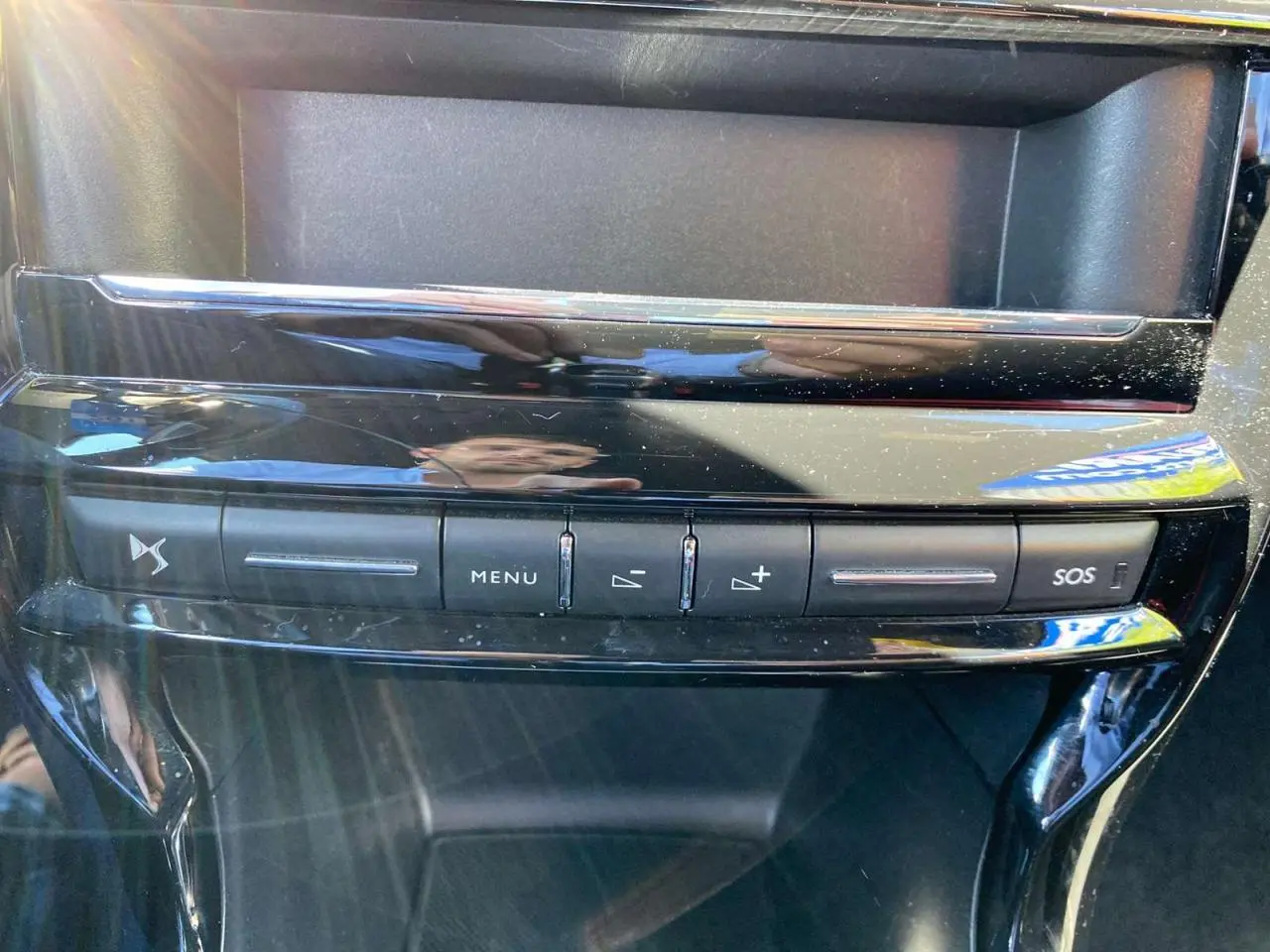 Vue rapprochée de la console centrale noire brillante du DS3 2018 avec boutons de menu et alerte SOS.