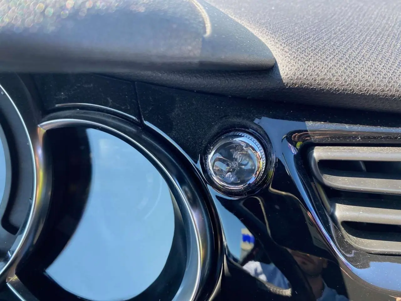 Gros plan sur la commande de réglage des rétroviseurs sur tableau de bord noir brillant d’une DS3.
