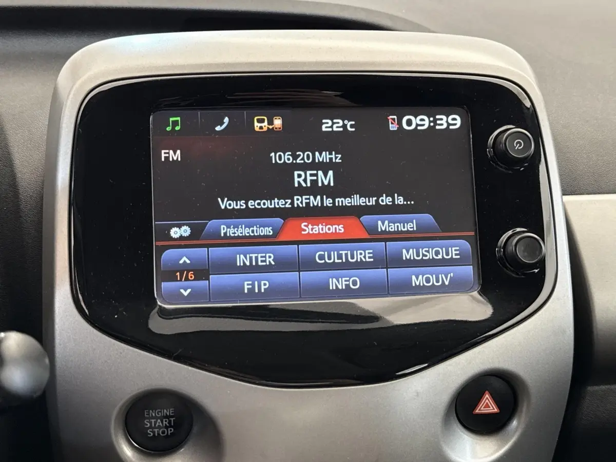Écran tactile central de la Toyota Aygo 2017 gris clair affichant les stations radio FM avec commandes autour.