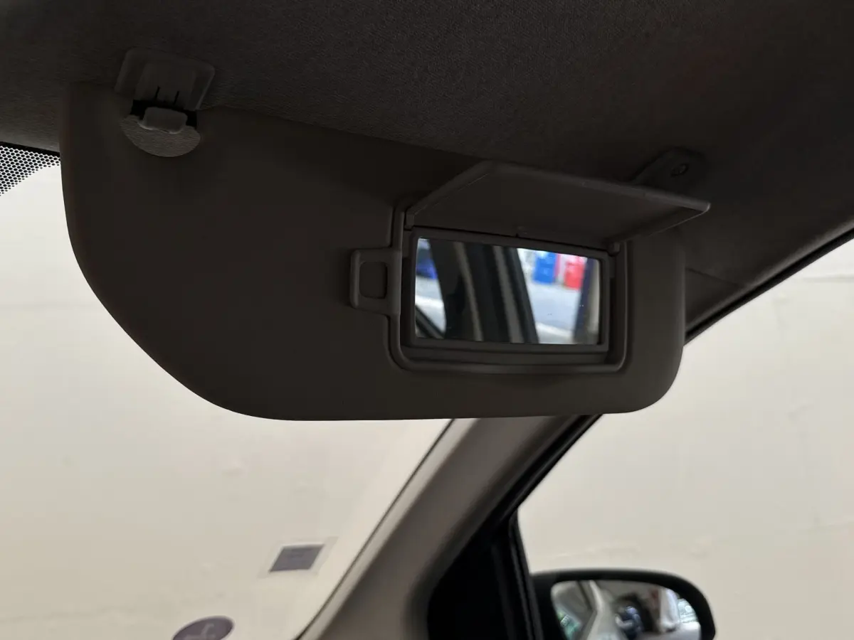 Détail du pare-soleil côté conducteur avec miroir de courtoisie ouvert dans une Toyota Aygo gris clair.