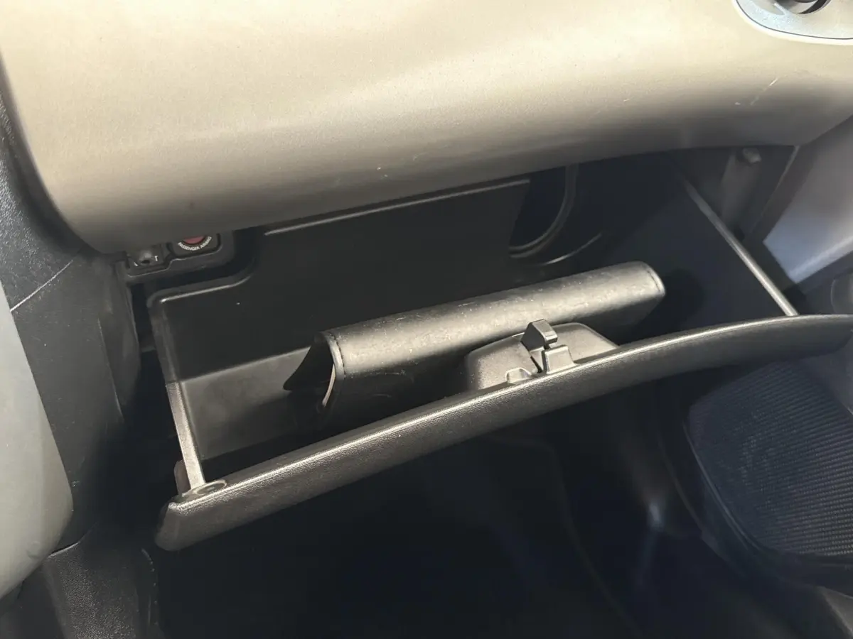 Gant de boîte à gants ouvert côté passager dans l’habitacle d’une Toyota Aygo gris clair 2017.