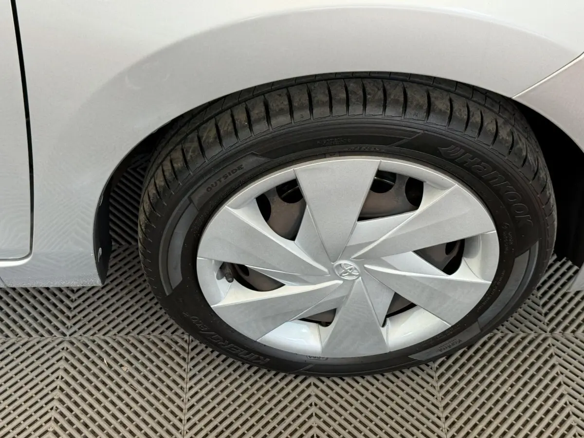 Gros plan sur la roue avant droite gris clair d'une Toyota Aygo 2017 avec enjoliveur au design géométrique.