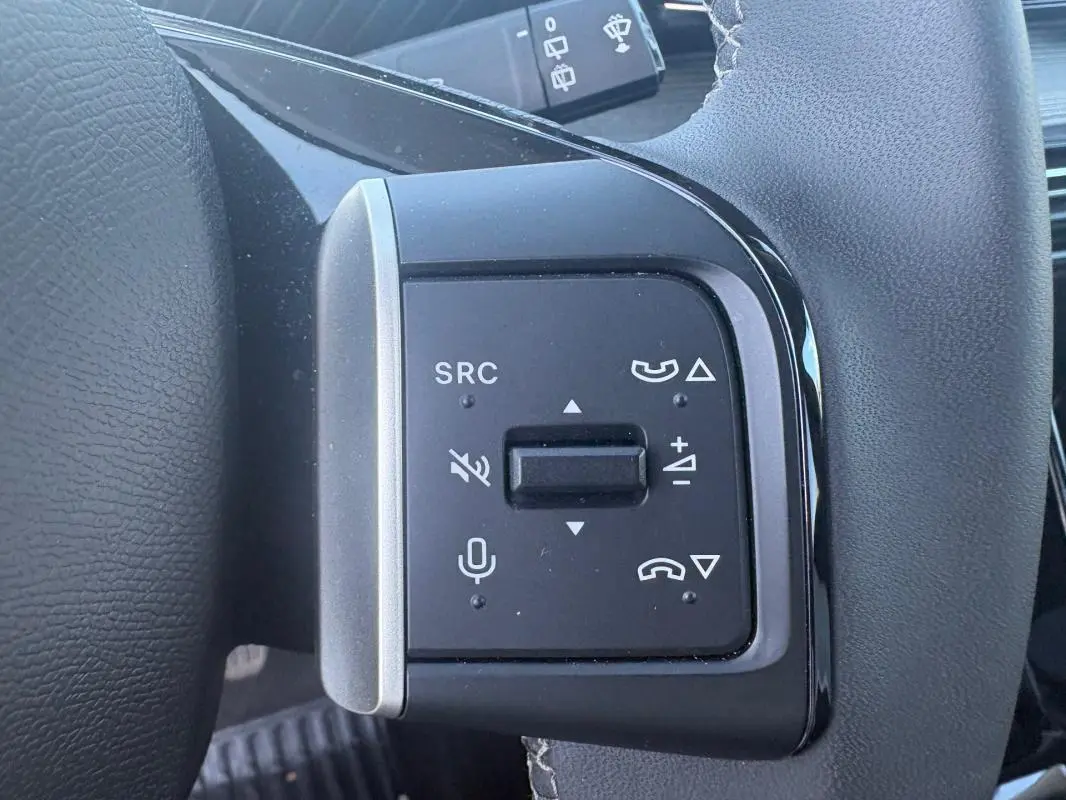 Gros plan sur les commandes vocales et audio au volant du Citroën C3 gris foncé 2025, version Turbo 100 ch Manuelle Max.