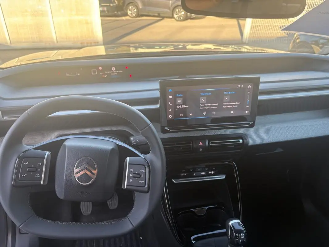 Vue intérieure du tableau de bord de la Citroën C3 2025 gris foncé, avec volant multifonction et écran tactile central.