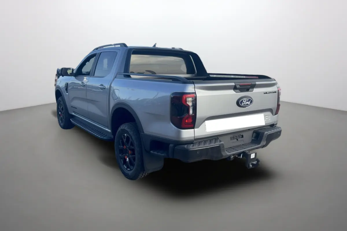 Ford Ranger Wildtrak gris iconic vu en 3/4 arrière droit avec barres de toit et attelage visible.