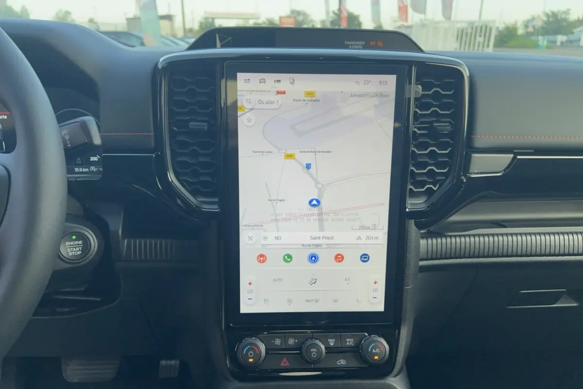 Intérieur du Ford Ranger Wildtrak 2026 vu de face, écran tactile central affichant la navigation, tableau de bord noir.