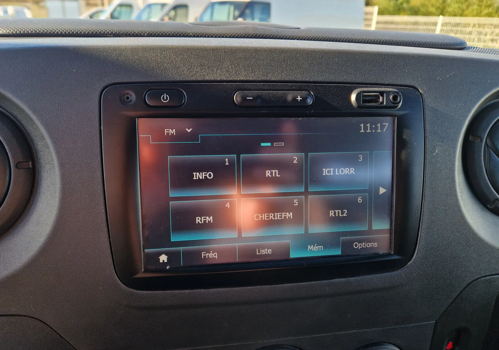 Écran tactile central du tableau de bord du Renault Master blanc, affichant les stations radio FM, vue de face.