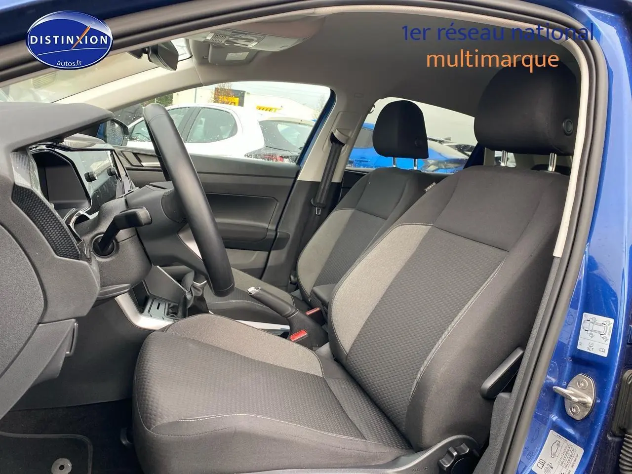 Intérieur avant côté conducteur d'une Volkswagen Polo bleu récif, sièges tissu noir et gris, volant cuir multifonction.