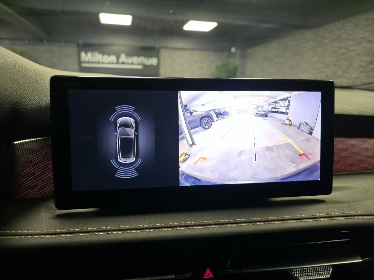 Écran digital intérieur affichant la caméra de recul et le radar de stationnement de l'Alfa Romeo Tonale gris.