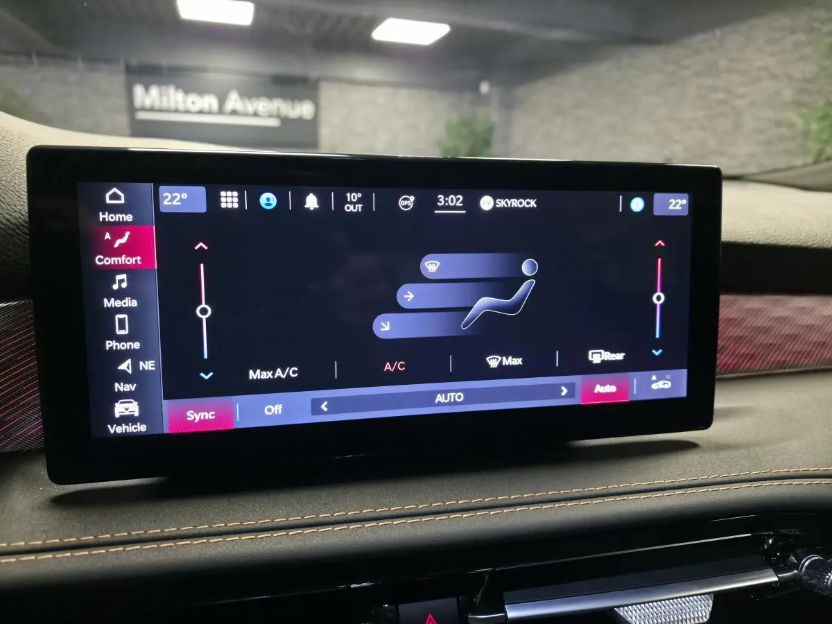 Écran tactile central de l'Alfa Romeo Tonale 2023 affichant les réglages de climatisation dans un intérieur noir avec surpiqûres beige.