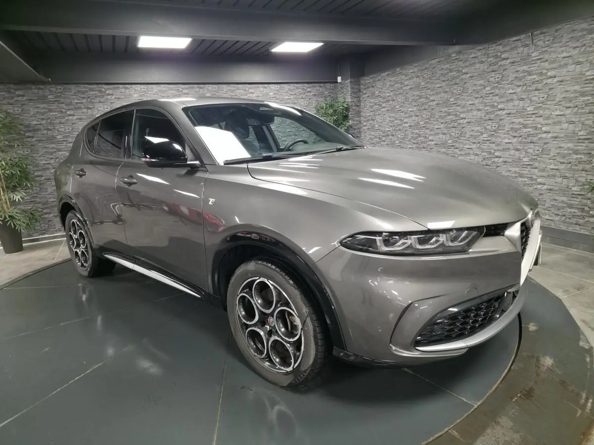 Vue 3/4 avant gauche d'une Alfa Romeo Tonale gris métallisé avec jantes 18 pouces et rétroviseurs noirs brillants.