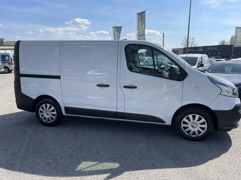 Vue latérale côté droit d’un Renault Trafic Fourgon blanc L1H1, avec portes coulissantes et jantes acier.