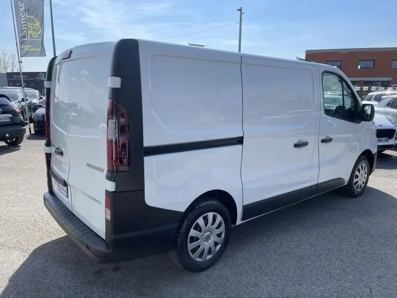 Vue 3/4 arrière droite d’un Renault Trafic Fourgon blanc L1H1 avec détails noirs sur pare-chocs et portières.