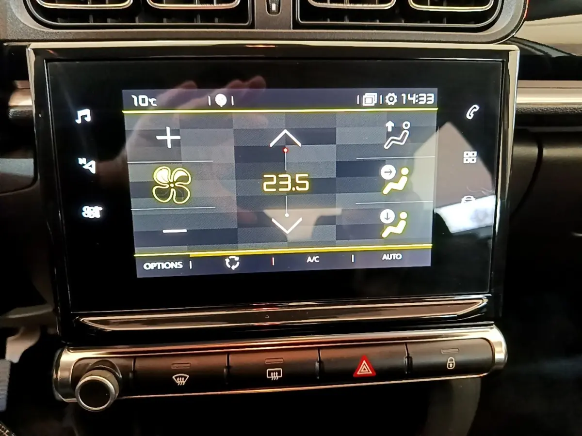 Écran tactile central affichant la climatisation à 23,5°C dans une Citroën C3 blanche, vue intérieure rapprochée.