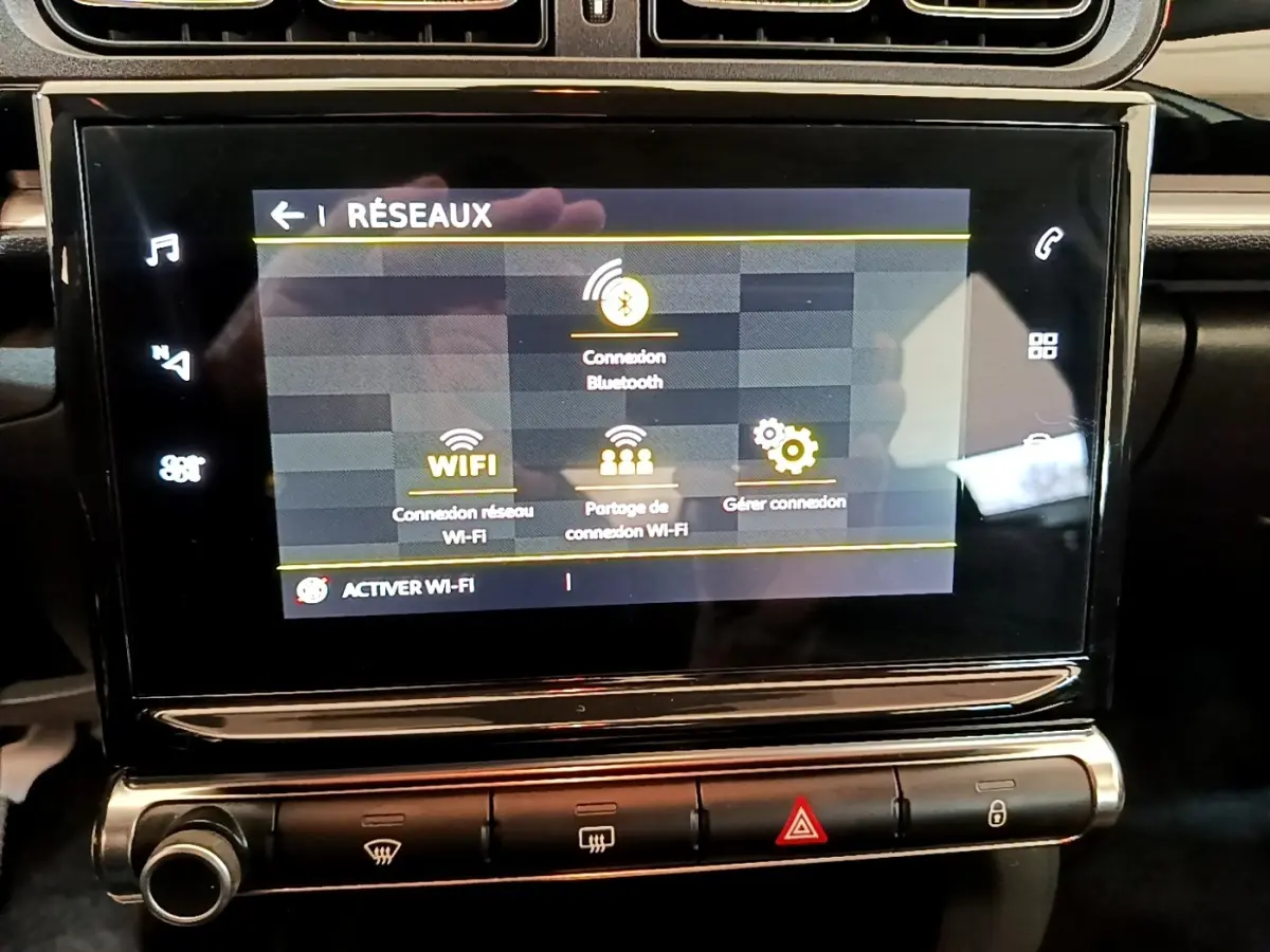 Écran tactile central du tableau de bord de la Citroën C3 blanche, affichant les options de connexion réseau Wi-Fi et Bluetooth.