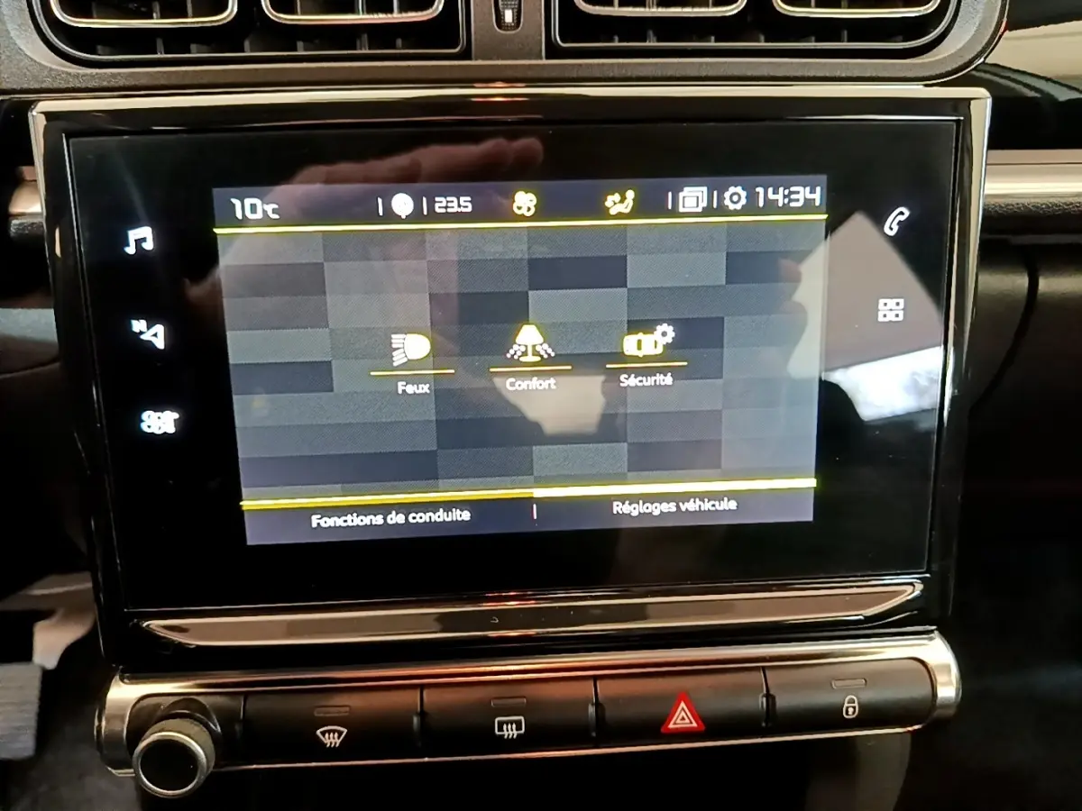 Écran tactile central de la Citroën C3 blanche, affichant les réglages de conduite et sécurité.