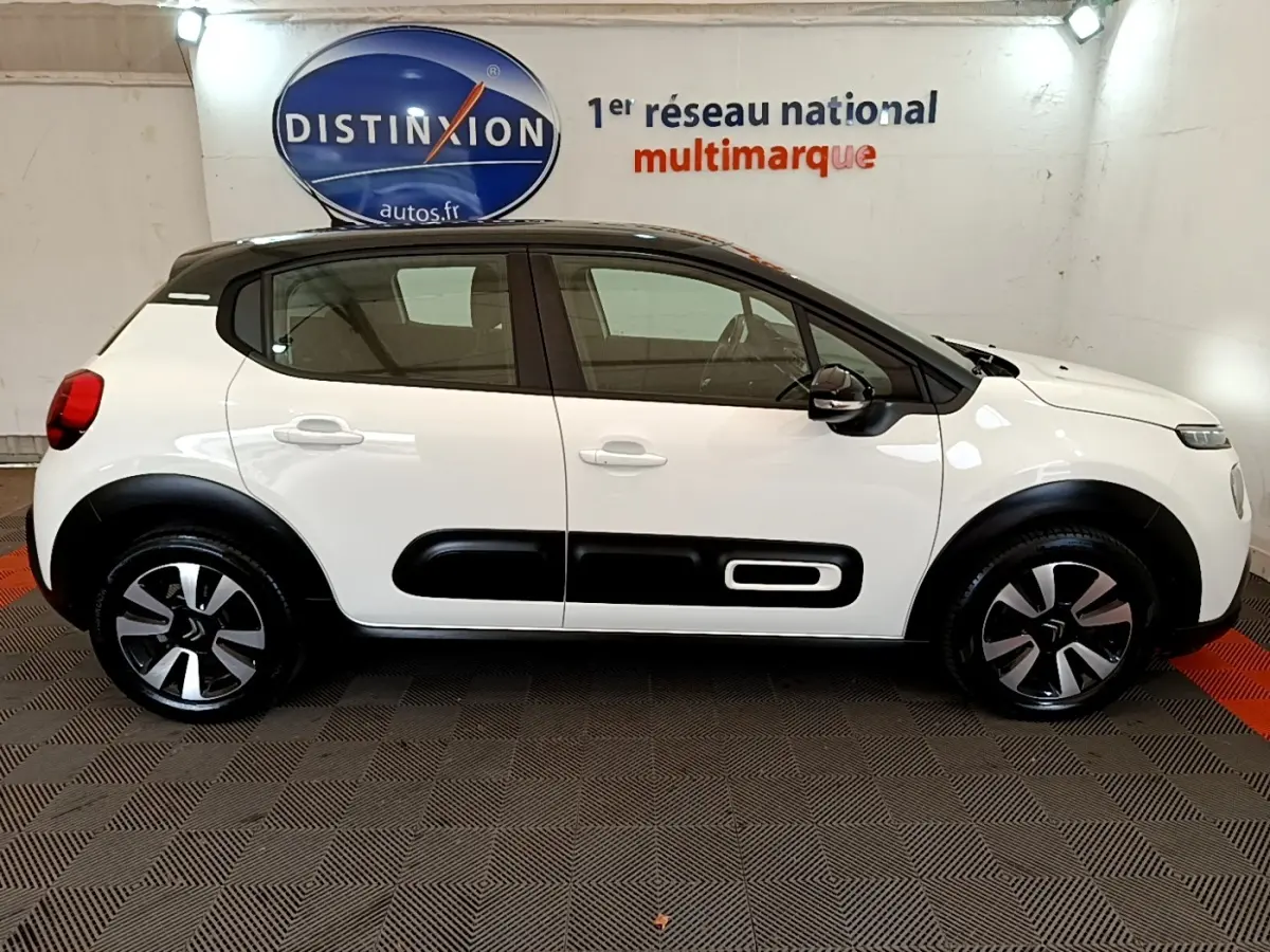 Profil droit d'une Citroën C3 blanche 2021 avec toit noir et protections latérales noires distinctives.