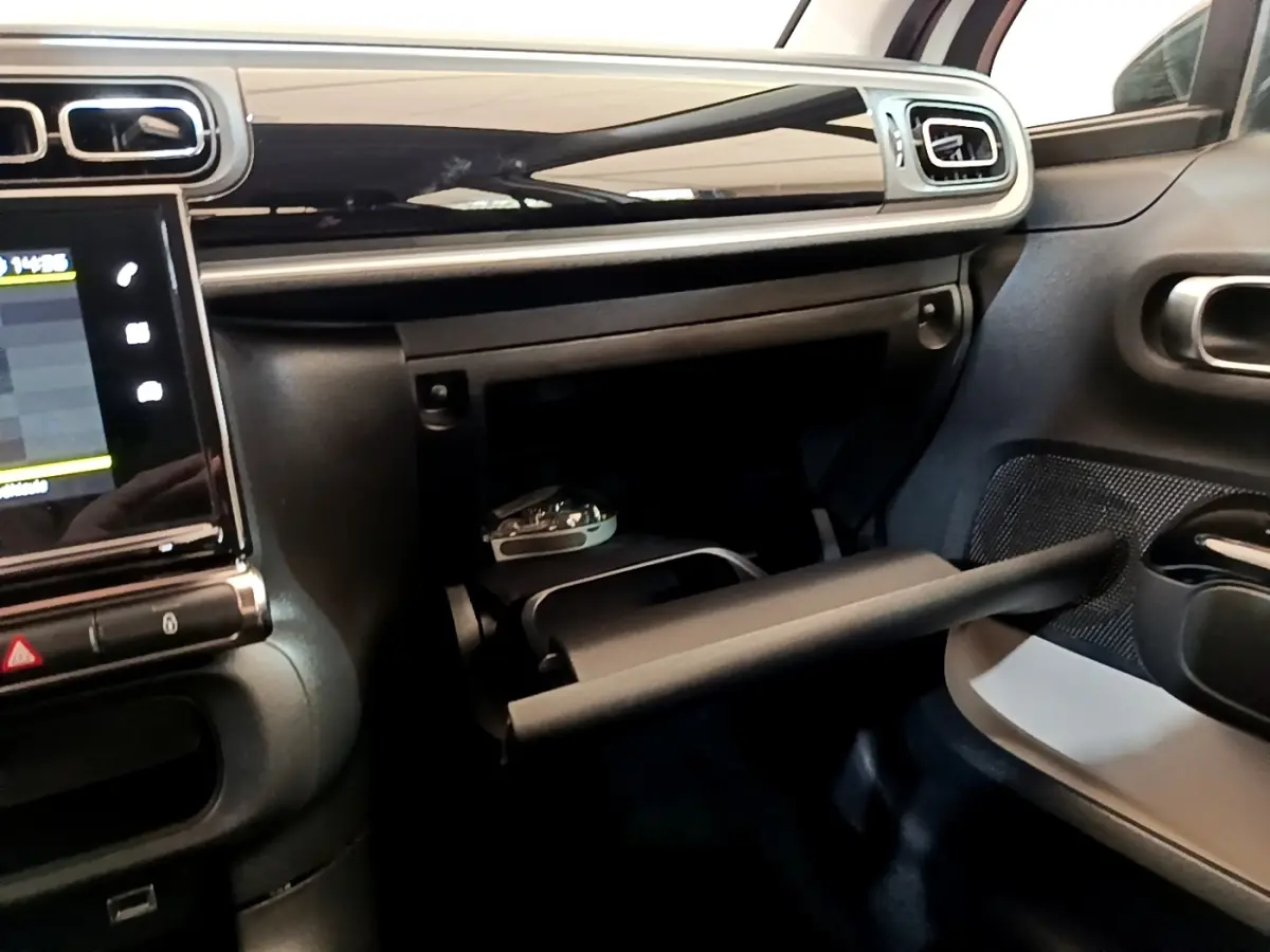 Intérieur de la Citroën C3 2021 blanc, vue du tableau de bord côté passager avec boîte à gants ouverte.