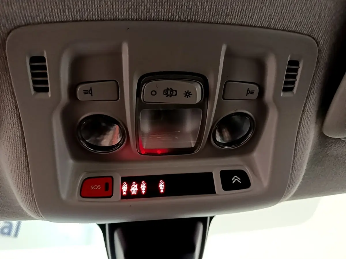 Vue en gros plan du plafonnier intérieur de la Citroën C3 blanche, avec boutons d’éclairage et alerte SOS allumée.