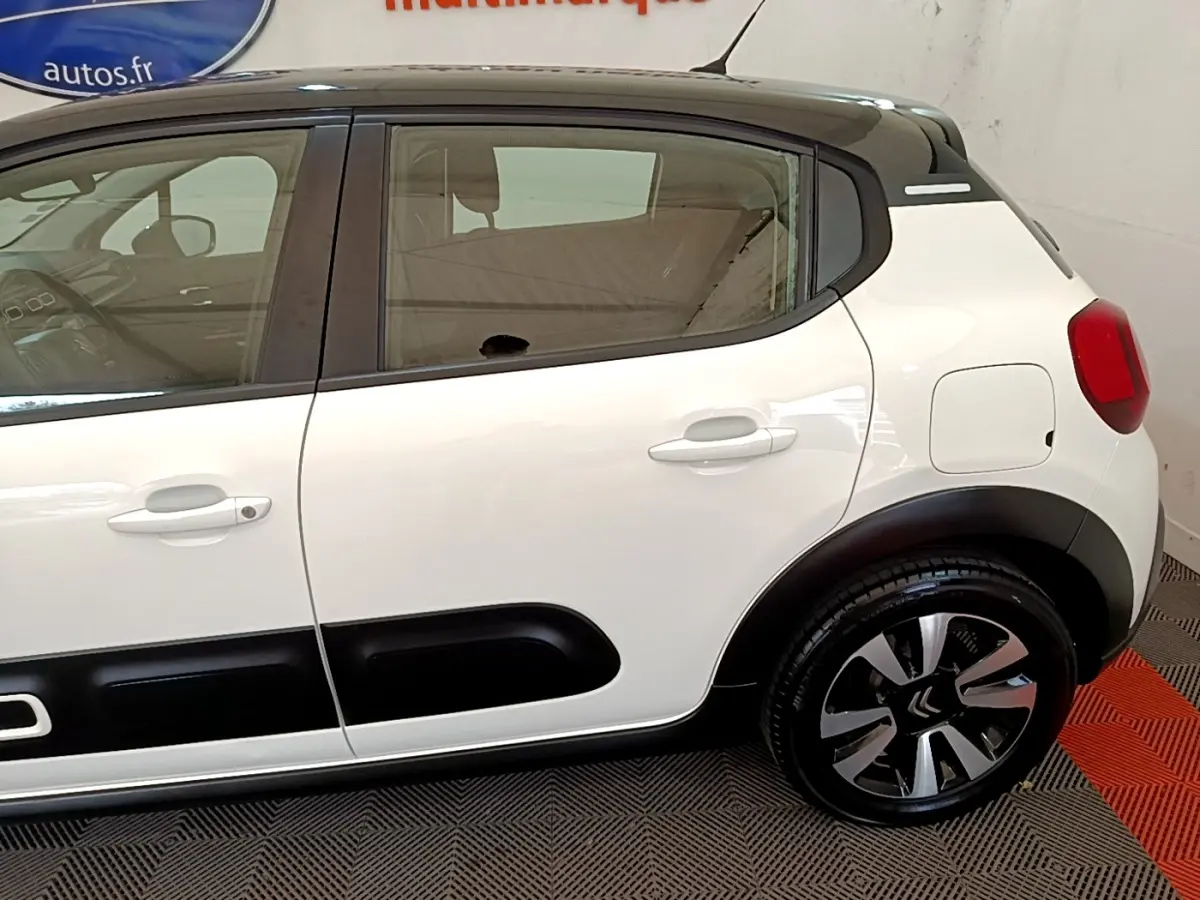 Vue latérale droite d'une Citroën C3 blanche 2021 avec toit noir et protections latérales noires distinctives.