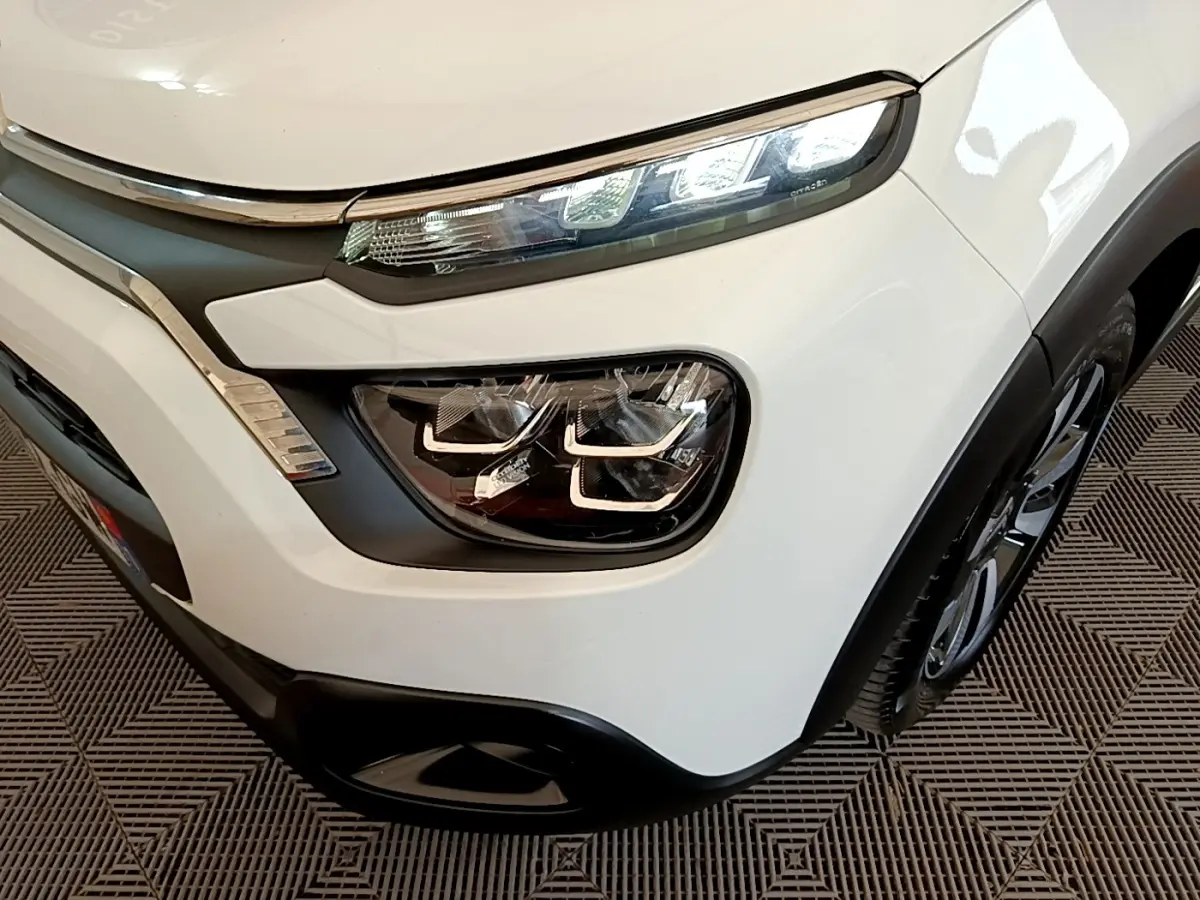 Gros plan sur l’avant droit blanc d’une Citroën C3 2021 avec phares LED et détails chromés distinctifs.