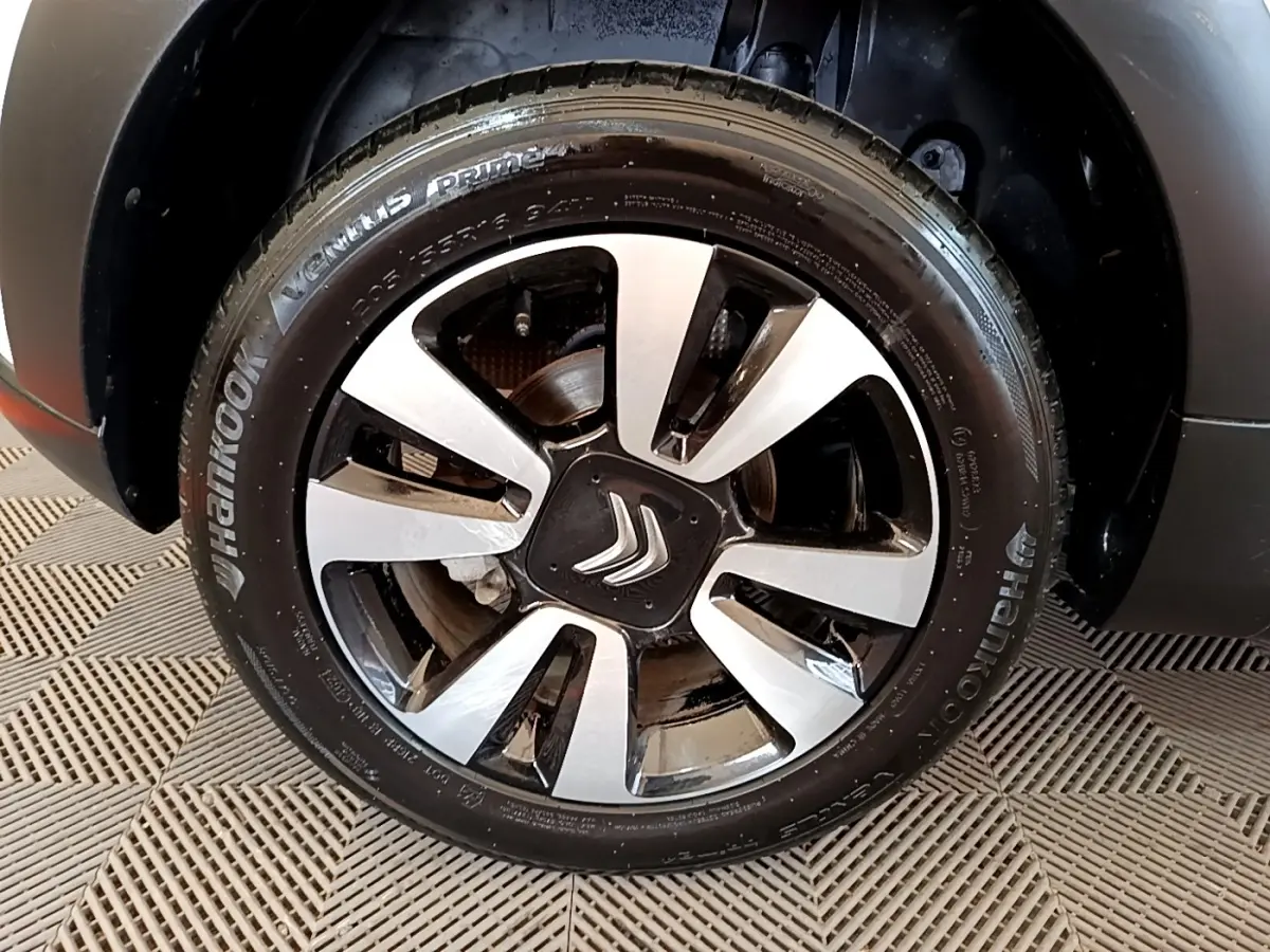 Gros plan sur la roue avant droite d'une Citroën C3 blanche, avec jante alliage bicolore et logo Citroën central.