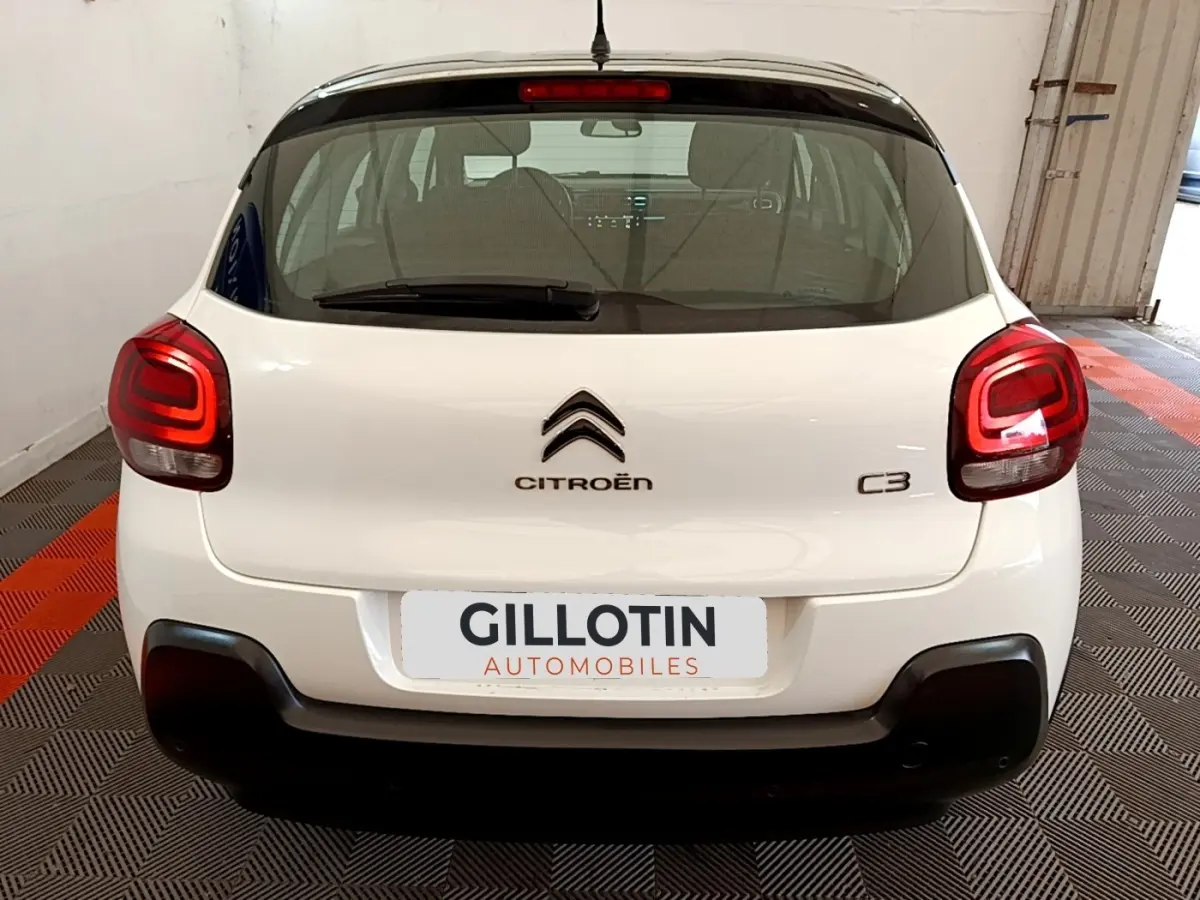 Vue arrière d'une Citroën C3 blanche 2021 avec feux arrière LED et logo centré sur un sol à damier noir et rouge.