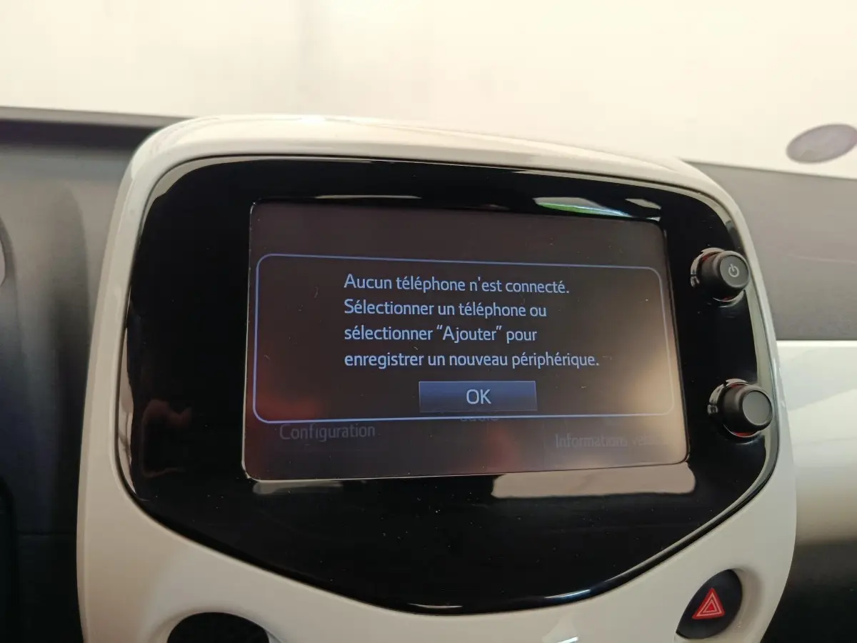 Écran tactile central de la Toyota Aygo blanc 2016 affichant un message de connexion Bluetooth.