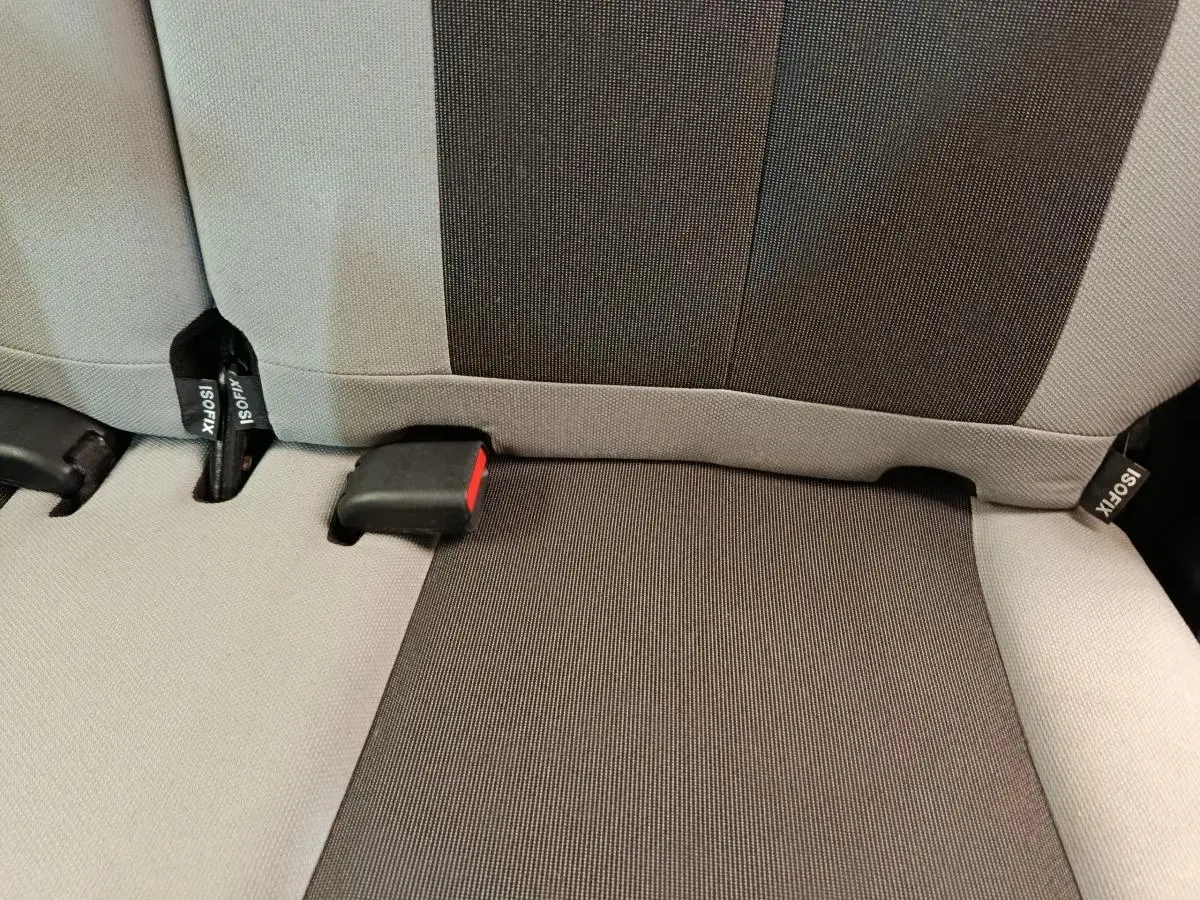 Gros plan sur la banquette arrière bicolore gris clair et foncé de la Toyota Aygo 2016, montrant les attaches Isofix.