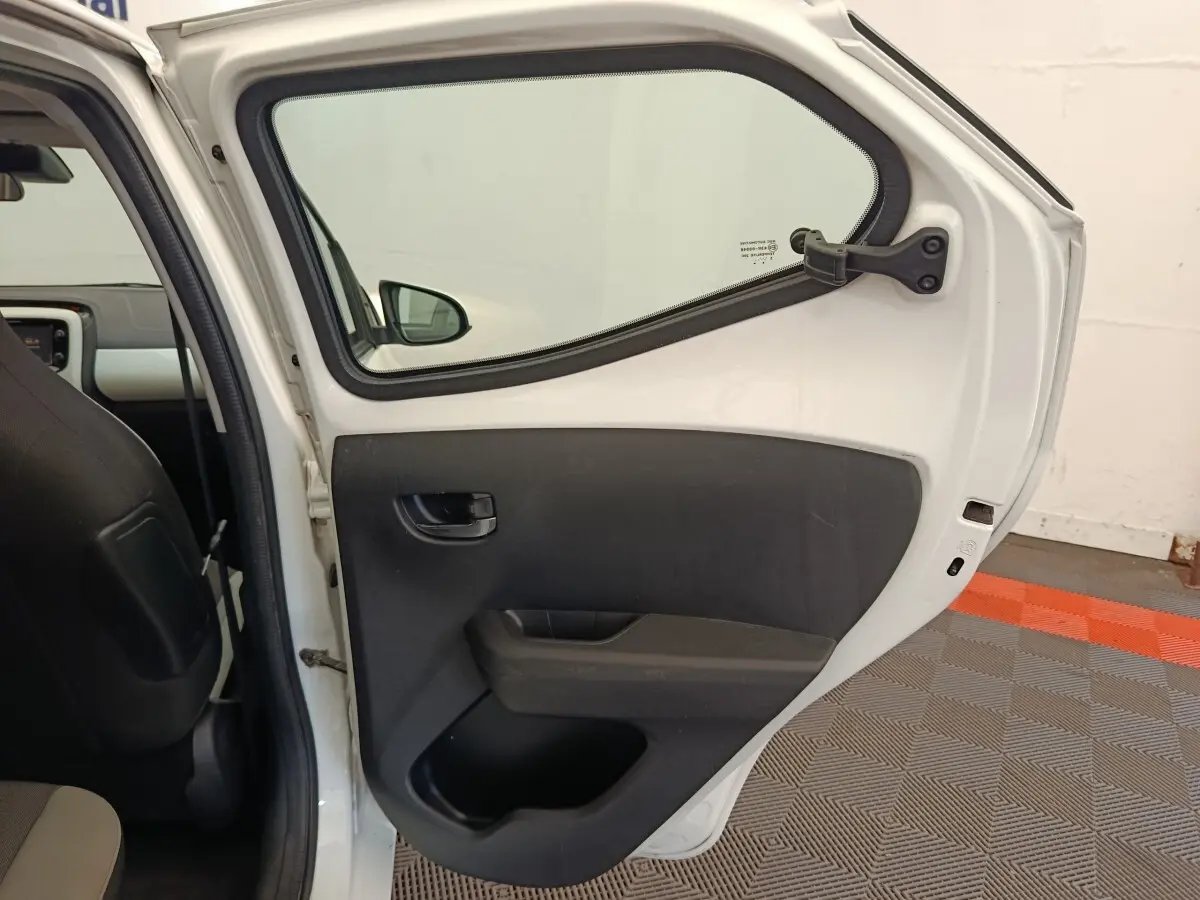 Vue intérieure de la porte arrière droite blanche d'une Toyota Aygo 2016 avec garniture noire et poignée intégrée.