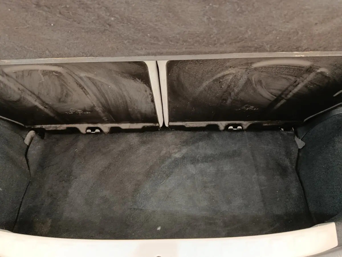 Vue du coffre arrière ouvert de la Toyota Aygo blanc 2016, montrant l'espace de rangement avec banquette rabattue.
