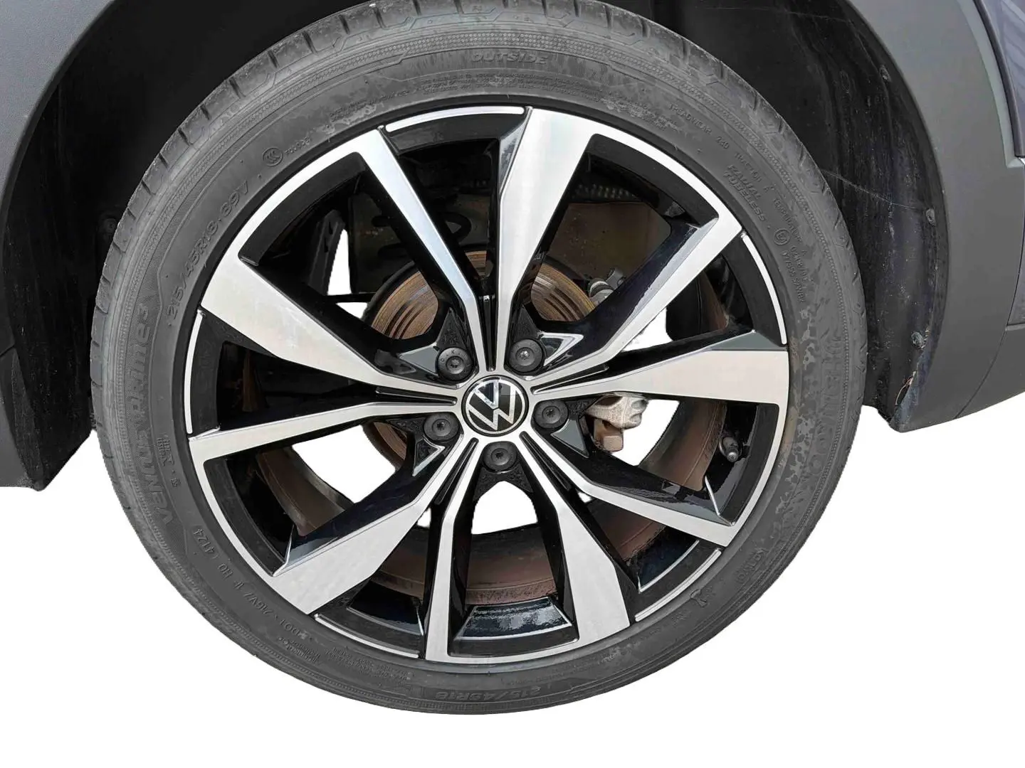 Gros plan sur la jante alliage 18 pouces bicolore noire et argentée du Volkswagen T-Cross gris, côté droit.