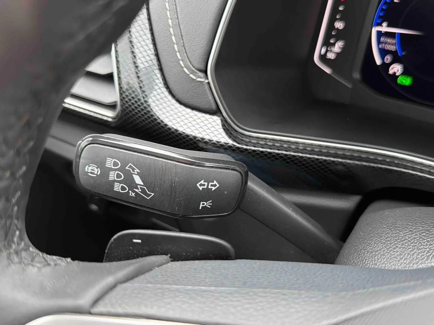 Gros plan sur la manette de clignotant noire à gauche du volant dans l’habitacle du Volkswagen T-Cross gris 2025.