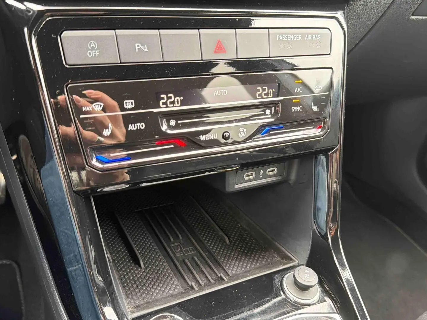 Gros plan sur la console centrale noire du Volkswagen T-Cross 2025 avec commandes climatisation digitale et ports USB-C.