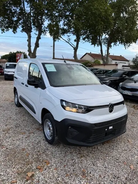 Citroën Berlingo blanc en version utilitaire, vue 3/4 avant droite sur un parking extérieur.